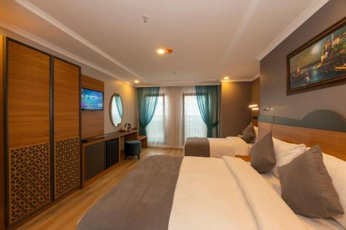 a hotel room with two beds and a television at New Emin Hotel in Istanbul
