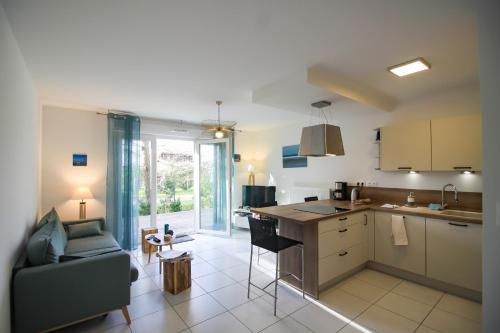 une cuisine et un salon avec un canapé et une table dans l'établissement La Carasse, à Lège-Cap-Ferret
