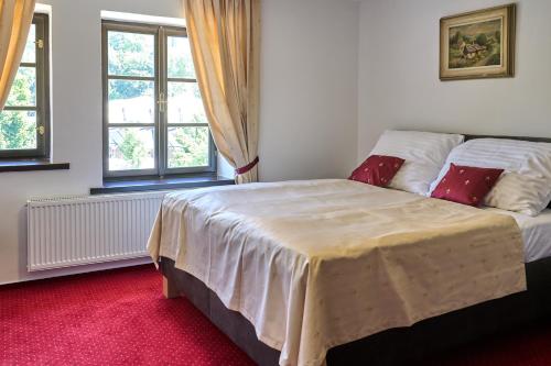 a bedroom with a large bed and two windows at Vila Lovců králových in Český Krumlov