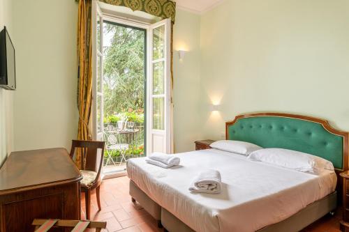 a bedroom with a large bed and a window at Hotel Villa San Michele in Lucca