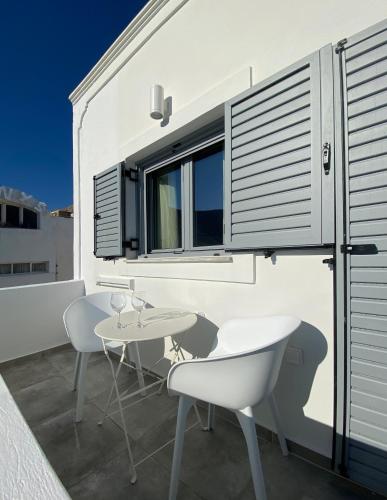 a balcony with a table and chairs and a window at Marton Perissa in Perissa