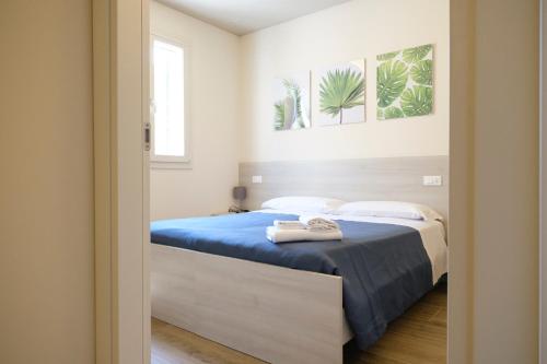 a bedroom with a bed with a blue comforter at Albergo Zoello Je Suis in Castelvetro di Modena