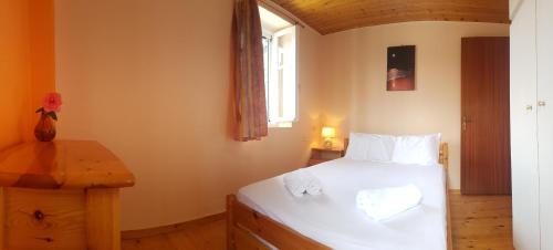 a bedroom with a white bed and a window at Karydia Apartments in Lazaráta