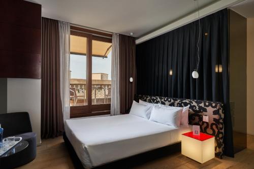 una camera d'albergo con letto e finestra di Mercer Casa Torner i Güell a Vilafranca del Penedès