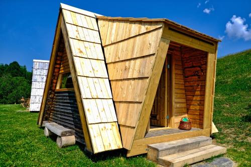 a small wooden house with stairs in the grass at Glamping Brodej in Vitanje