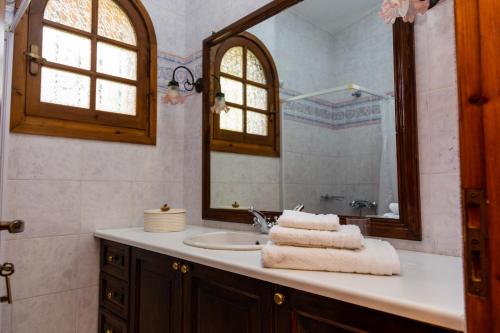 a bathroom with a sink and a mirror at Tzitzikari, Private Cottage in a Citrus Garden in Káto Melidhóni