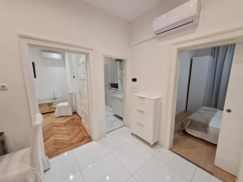 Habitación blanca con cama y baño. en Apartment Lido 50m From The Beach, en Opatija