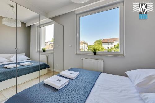 1 dormitorio con 2 camas y ventana en MS Apartments Green Hill I, en Gdynia