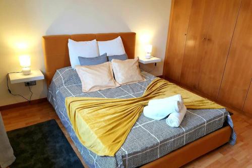 a bedroom with a bed with two lamps on two tables at Hill & Sea House in Ribeira Grande