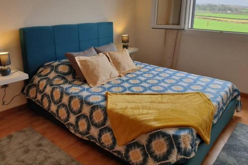 um quarto com uma cama azul com almofadas e uma janela em Hill & Sea House em Ribeira Grande