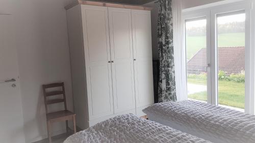 a bedroom with a bed and a large window at Wohnung Wiesengrün - Osserblick in Lam