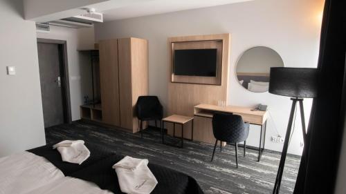 a bedroom with a bed and a desk and a mirror at Nowe Millenium in Świnoujście
