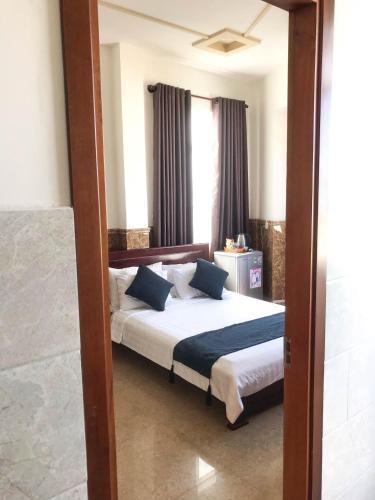 a bedroom with a bed and a mirror at La Cactus Hotel 2 in Quy Nhon