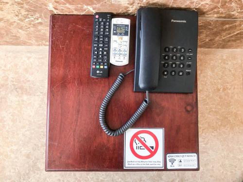 a telephone and a no smoking sign on a table at La Cactus Hotel 2 in Quy Nhon