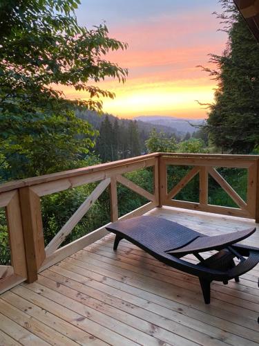 a hammock on a deck with the sunset in the background at Ostoja Rycerka in Rycerka Górna