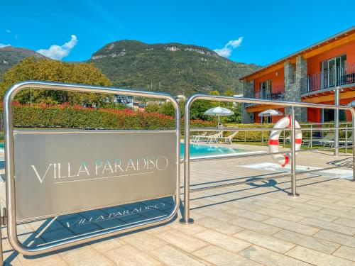 a sign for a villa paradiso resort with a swimming pool at Residence Villa Paradiso in Gravedona
