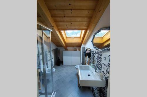 uma casa de banho com um lavatório e um espelho em La Pentajota • camera con vista em Mondovì