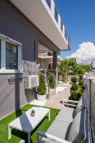 a patio with a white table and benches on a building at JT Apartments in Kissamos