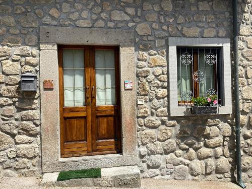 een stenen gebouw met een houten deur en een raam bij Casa Silvana Santa Fiora in Santa Fiora