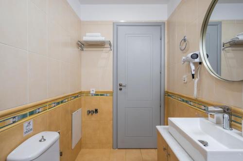 a bathroom with a sink and a mirror at JT Apartments in Kissamos