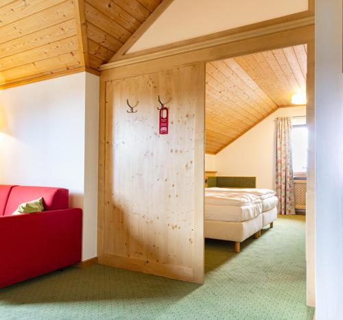 a room with a bed and a wall with a door at Glasl's Landhotel in Zorneding
