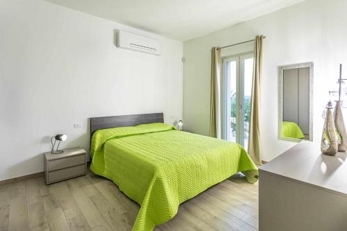 ein weißes Schlafzimmer mit einem grünen Bett und einem Fenster in der Unterkunft Suite romantic in Capranica