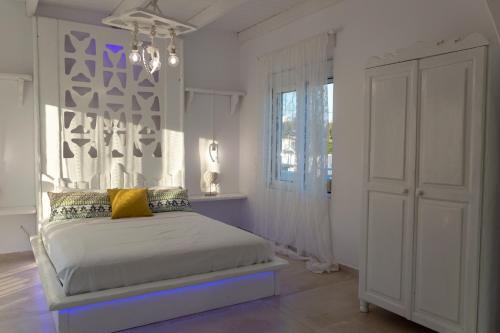 a white bedroom with a bed and a window at Seva's House in Psinthos