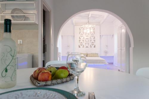 a table with a bowl of fruit and a wine glass at Seva's House in Psinthos