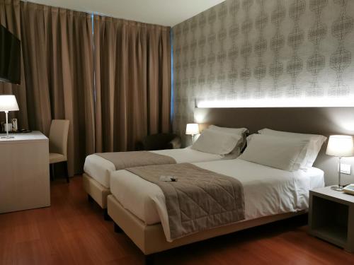 a hotel room with a large bed and two lamps at Hotel President in Prato