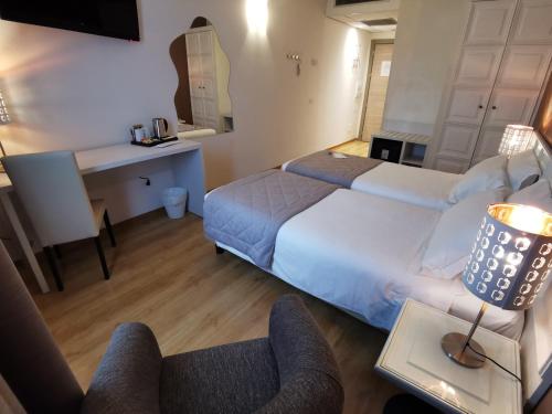 a hotel room with two beds and a desk at Hotel President in Prato