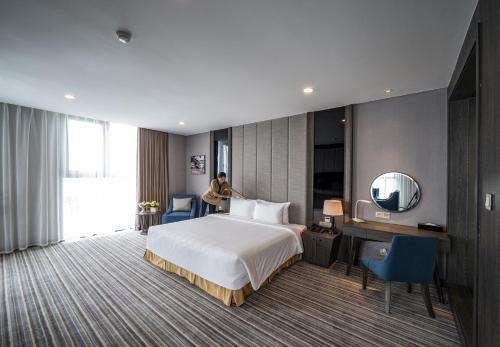a hotel room with a bed and a mirror at Muong Thanh Luxury Saigon Hotel in Ho Chi Minh City