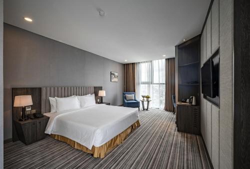 a hotel room with a bed and a flat screen tv at Muong Thanh Luxury Saigon Hotel in Ho Chi Minh City