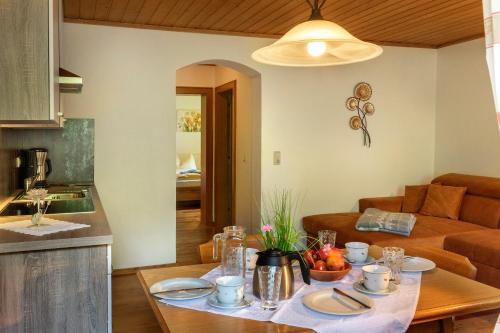 eine Küche und ein Wohnzimmer mit einem Tisch mit Essen in der Unterkunft Bauernhof Klausbauer in Großarl