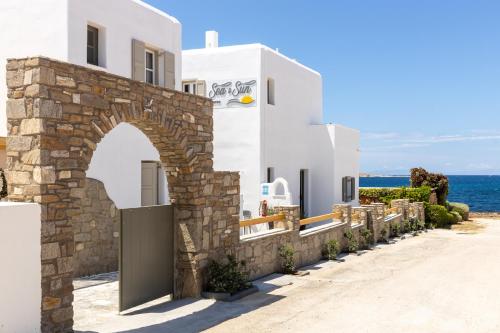 a building with an archway in front of the ocean at Sea & Sun Paros in Naousa