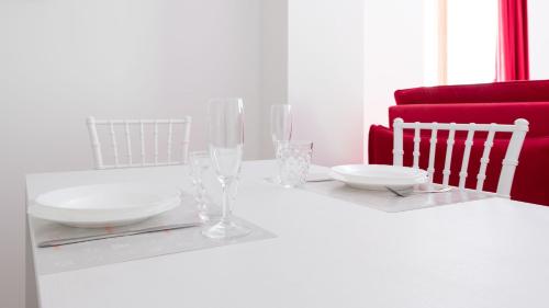 a white table with two plates and glasses on it at Italianway - Villa Tola in Valdisotto