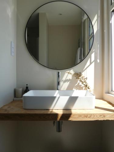 a bathroom with a white sink and a mirror at Harbour View House in St Ives