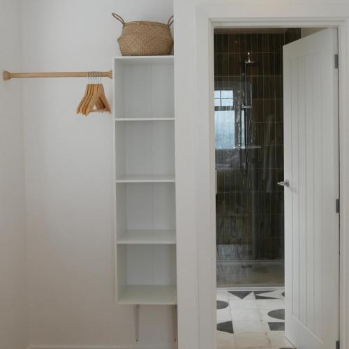 a bathroom with a walk in closet with a glass door at Harbour View House in St Ives