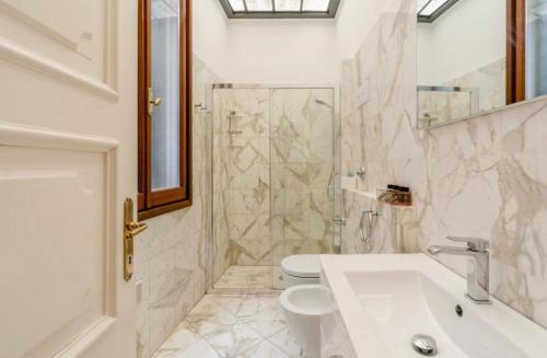 La salle de bains est pourvue de toilettes, d'un lavabo et d'une douche. dans l'établissement Venezia La Fenice, à Venise