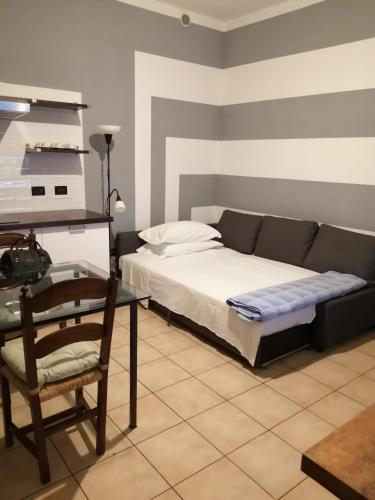 een slaapkamer met een bank, een tafel en een stoel bij Casa Vincenzo in Bologna