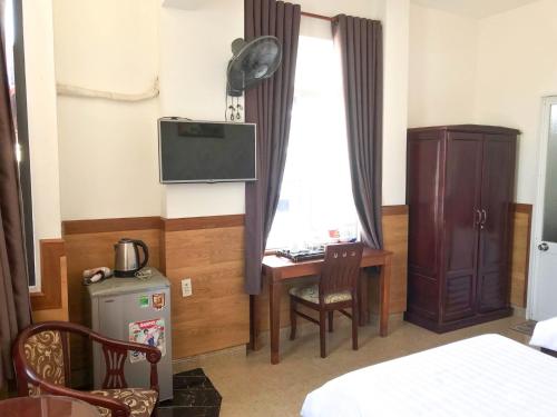 a bedroom with a desk and a window with a window at La Cactus Hotel 2 in Quy Nhon