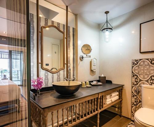 y baño con lavabo y espejo. en Riva Surya Bangkok - SHA Extra Plus en Bangkok