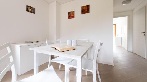 a white dining room with a white table and chairs at Italianway - Villa Tola in Valdisotto