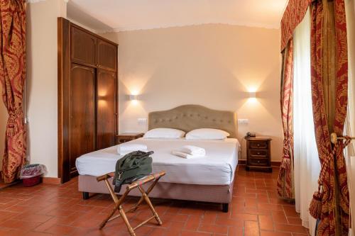 a hotel room with a bed and a chair at Hotel Villa San Michele in Lucca