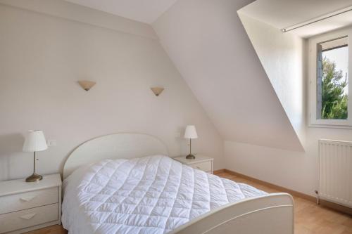 a white bedroom with a bed and a window at Vacances détente dans cette maison avec piscine à Crac'h in Crach