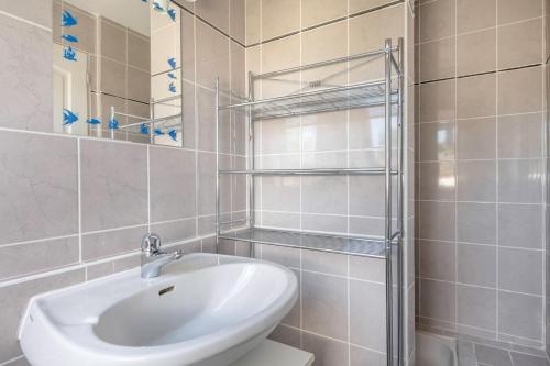 a white bathroom with a sink and a shower at Vacances détente dans cette maison avec piscine à Crac'h in Crach