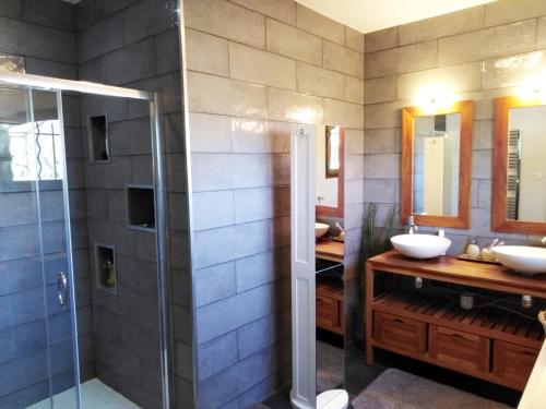 une salle de bain avec deux lavabos et une douche dans l'établissement Le Lou Mazet 1951, à Saint-Nazaire-des-Gardies