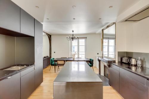 une cuisine avec un grand comptoir et une table dans l'établissement Beautiful apartment for 8 people, à Paris