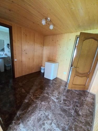 an empty room with a refrigerator and a bathroom at Family House in Makarovka