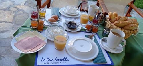 a table with plates of food and glasses of orange juice at Le Due Sorelle in Spilia