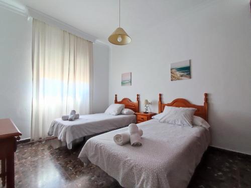 a bedroom with two beds with towels on them at Casa Rural Fuente de la Higuera in Ronda
